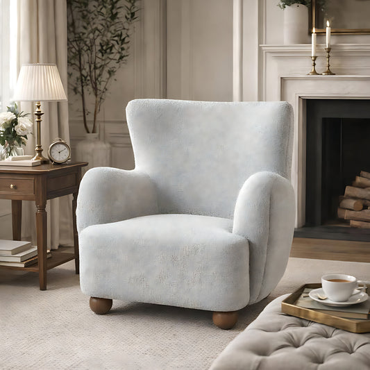 Light grey armchair in a cozy living room with a fireplace and side table.